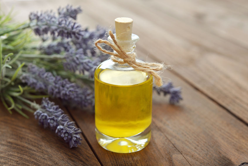 essential lavender oil with fresh flowers on wooden background closeup
